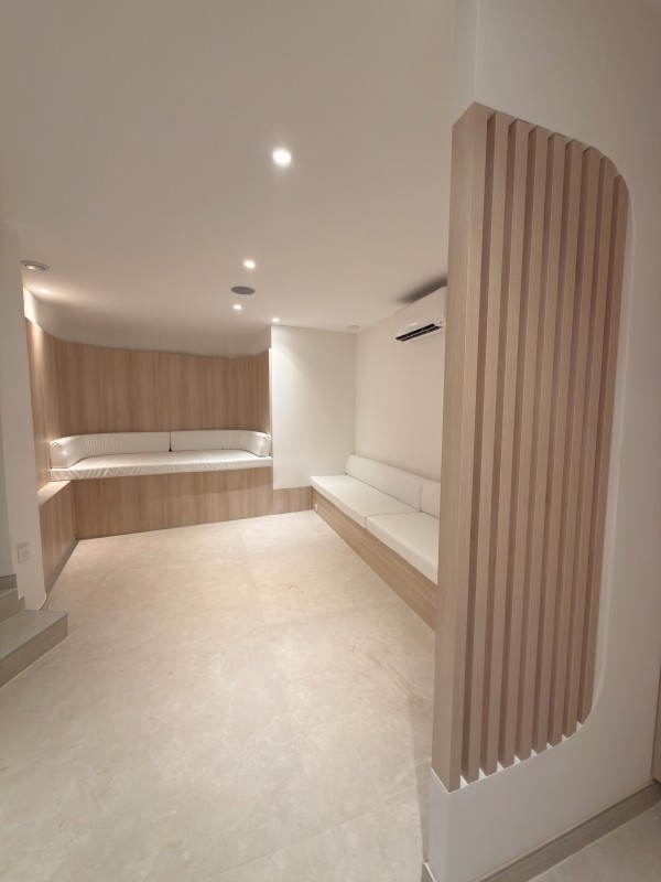 Agencement sur-mesure en bois avec claustra, habillage mural et banc d’accueil.